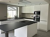 Cuisine blanche mat avec plan de travail en compact noir &agrave; Florennes  - Cuisines &eacute;quip&eacute;es design compl&egrave;tes Cr&eacute;a-M